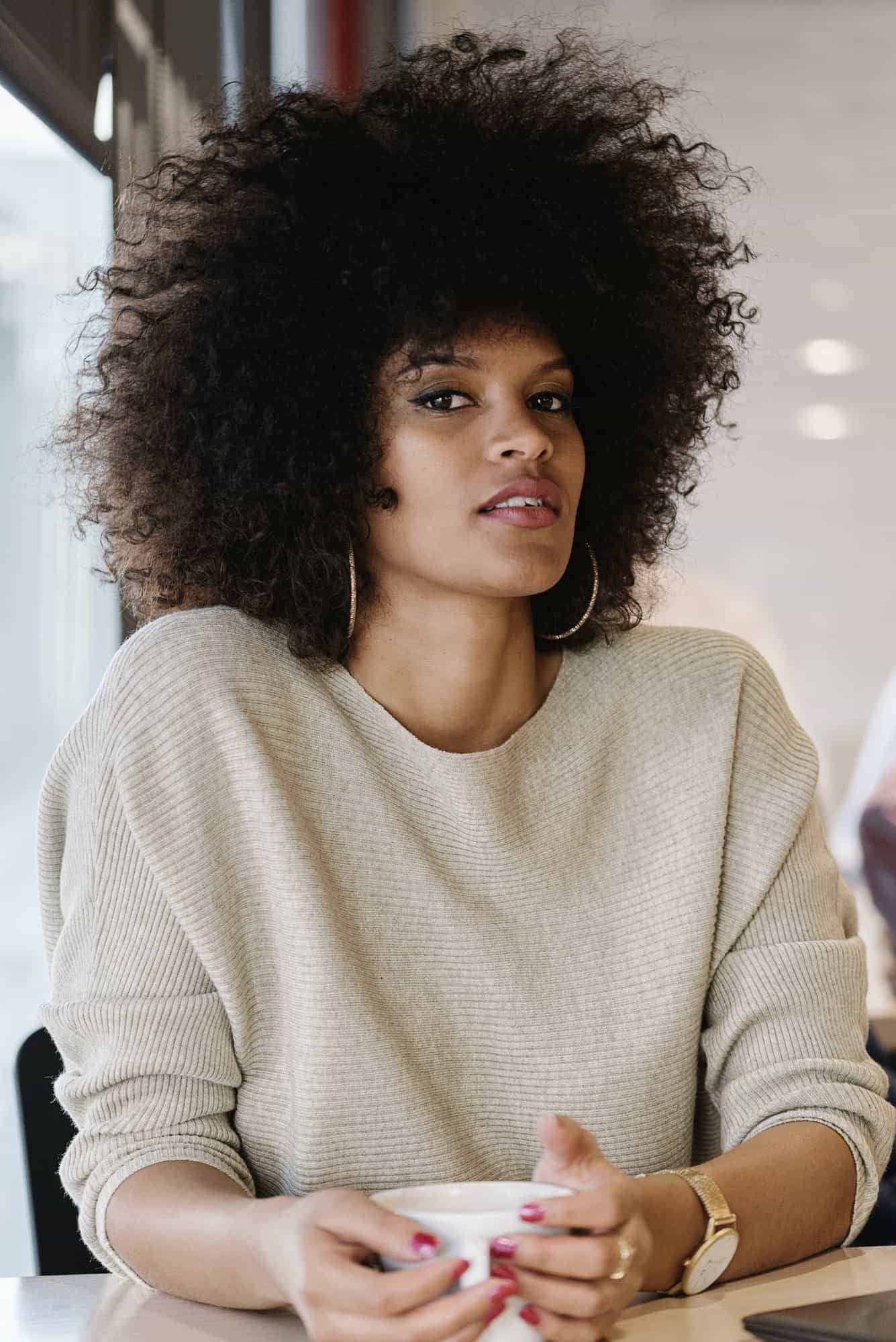 portrait of attractive afro woman in coffee shop