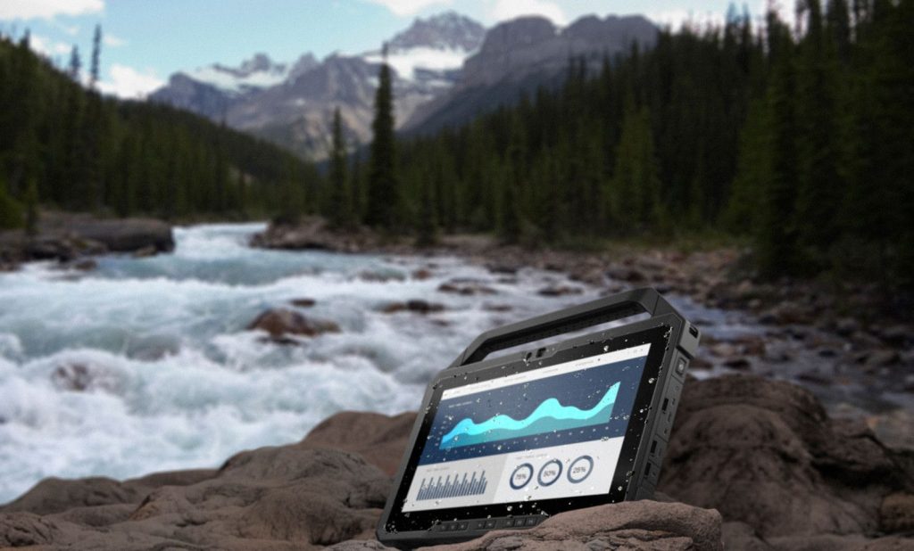 A rugged tablet beside a raging river.